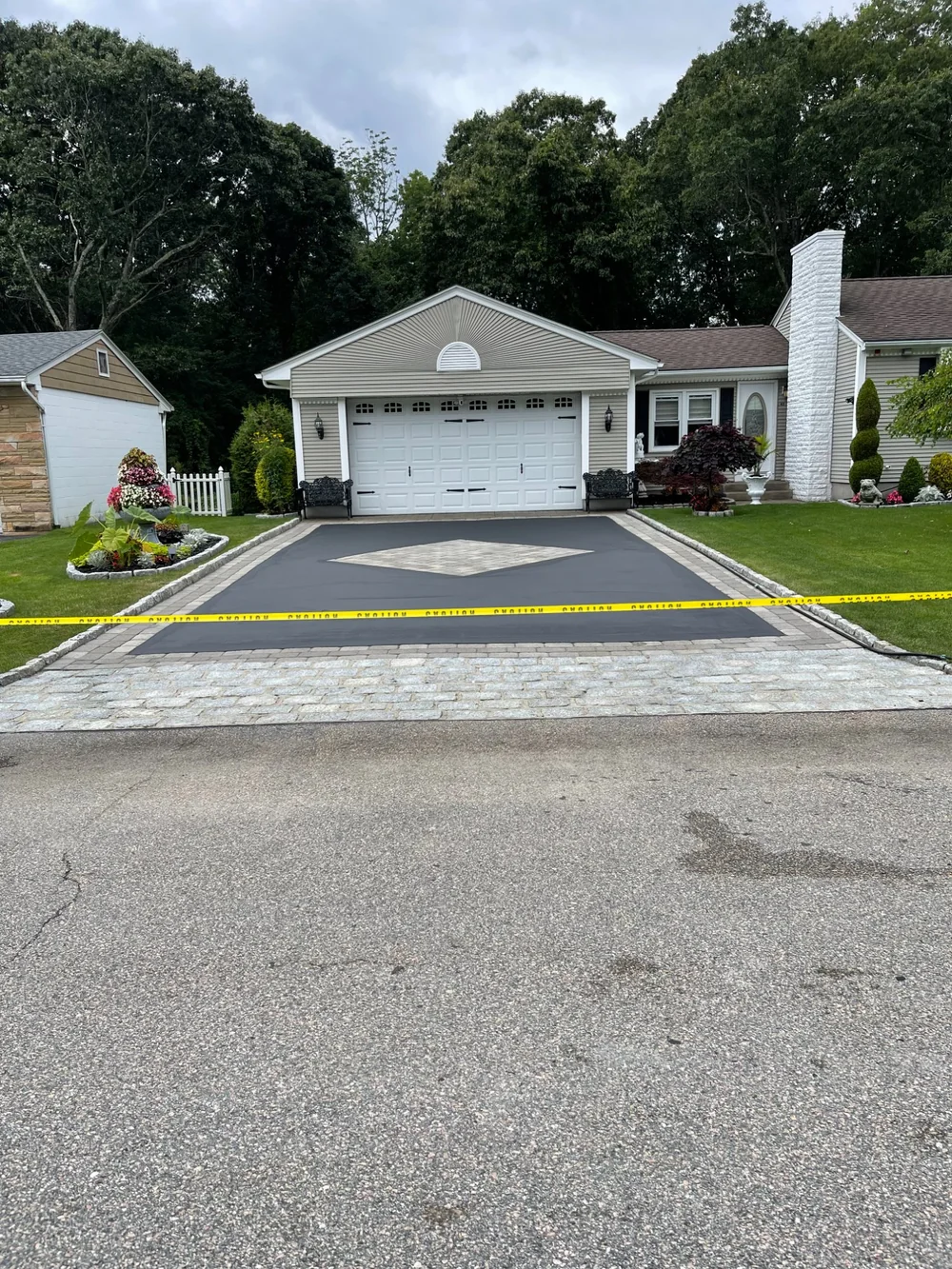 Residential driveway seal coating with decorative paver border